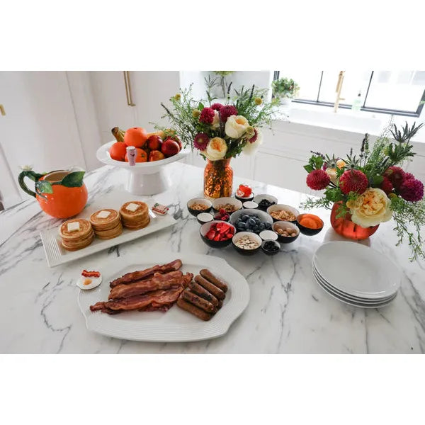 Nora Fleming Pretty Platter styled on a dining table with appetizers and a decorative mini.