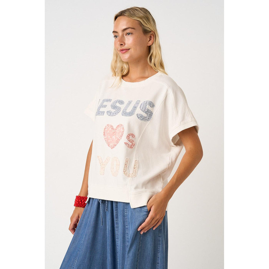 Mittoshop White Knit top featuring "Jesus Loves You" lettering patchwork, short sleeves, and a relaxed fit.