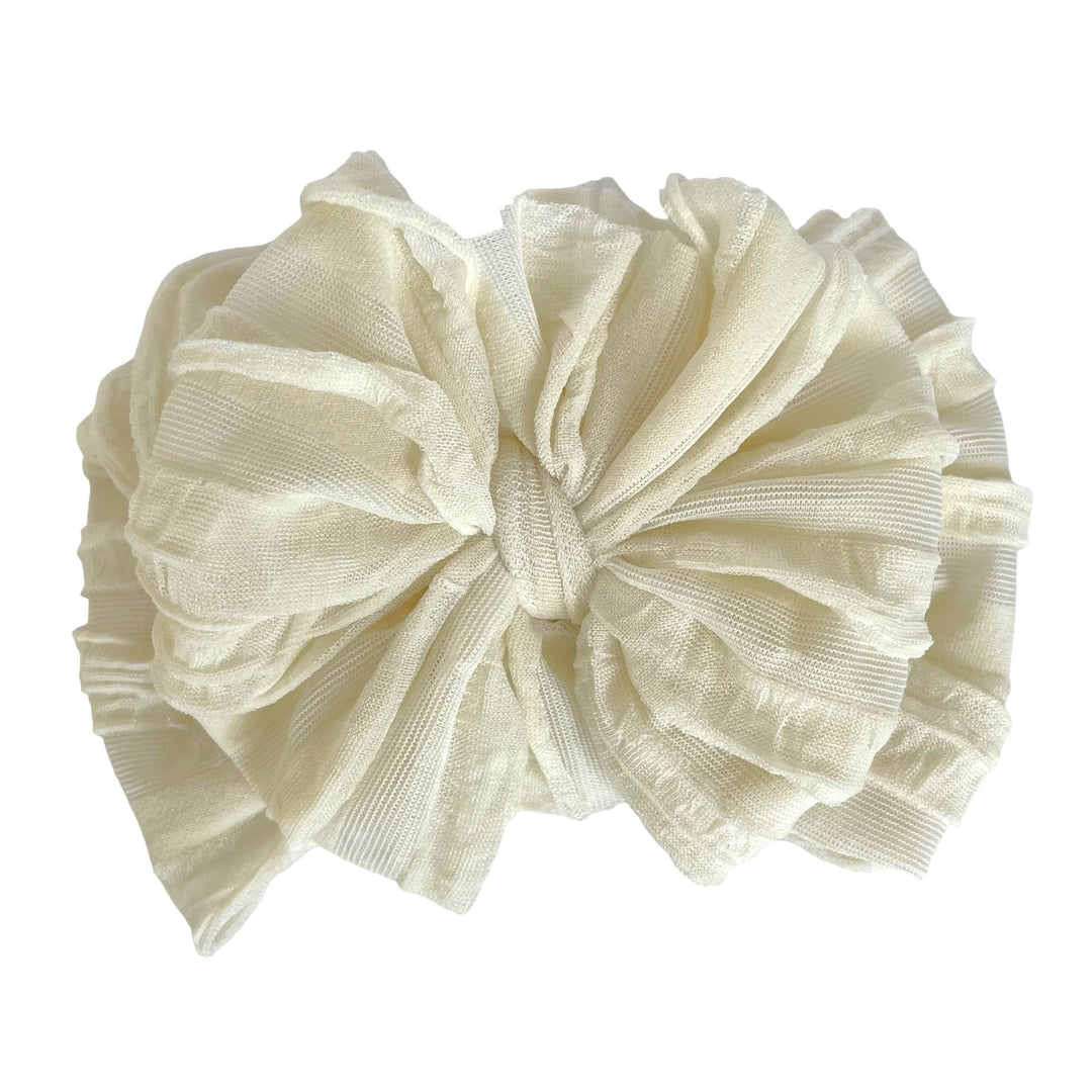 Rockin Royalty Ruffled Headband in Ivory; a plush, stretchy, and textured cream-colored headband for infants and toddlers.