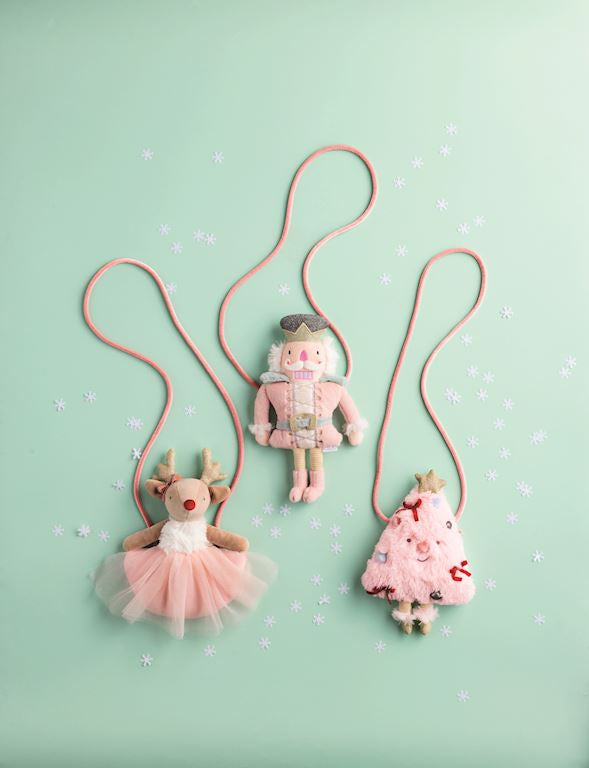Assortment of Mud Pie plush girls holiday purses featuring tulle embellishments, including a pink tree, pink reindeer, and nutcracker style.