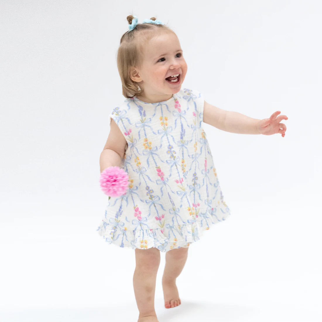 Baby girl wearing pink floral organic muslin ruffle back top and matching bloomers.