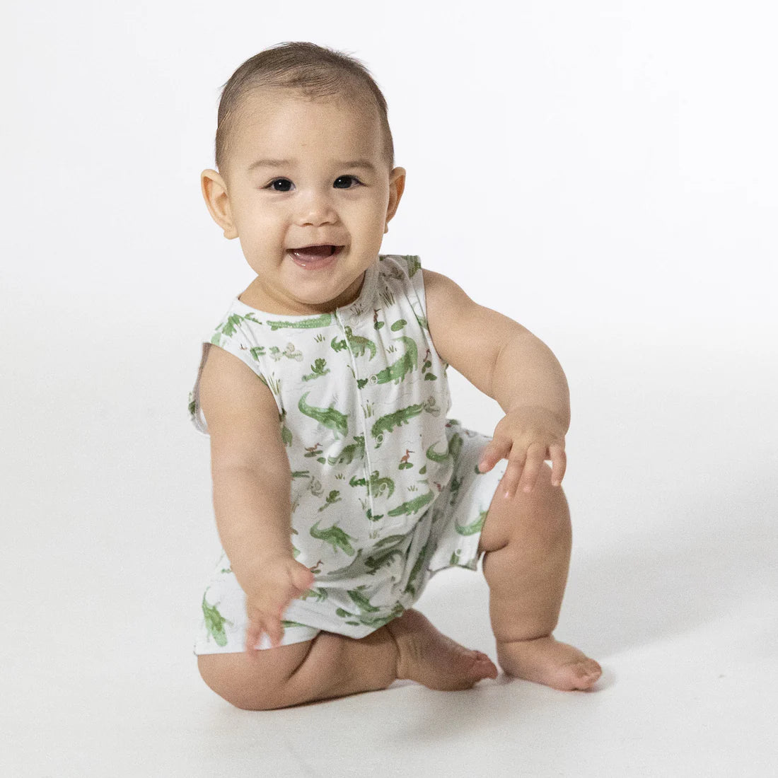 Infant sleeveless bamboo romper in white with colorful crayon alligator print.