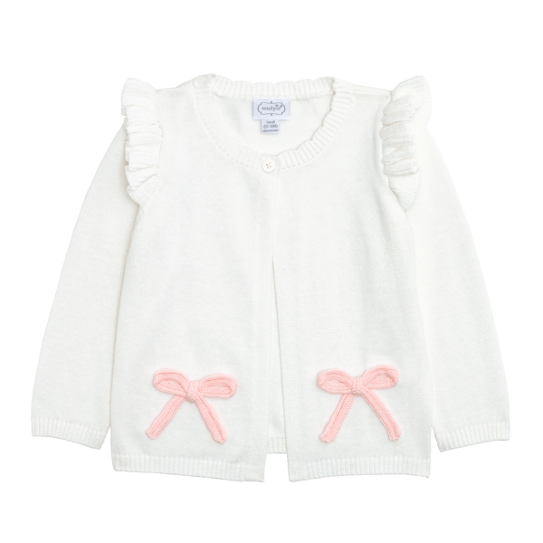 White Mud Pie baby cardigan with crochet bow accents and ruffle shoulders on a white background.
