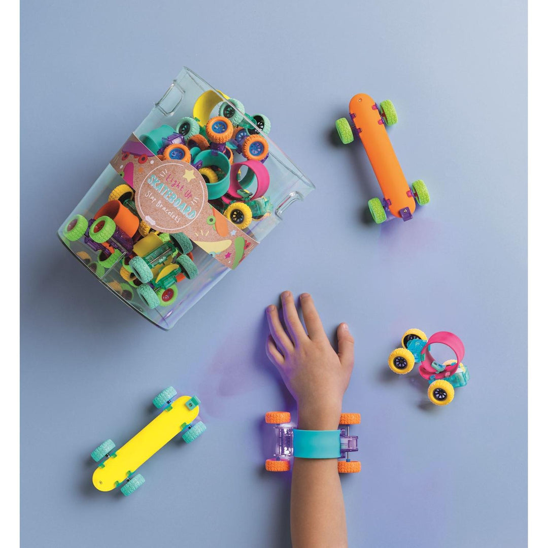 Acrylic display bucket filled with colorful Mud Pie skateboard slap bands featuring rolling wheels and LED lights.