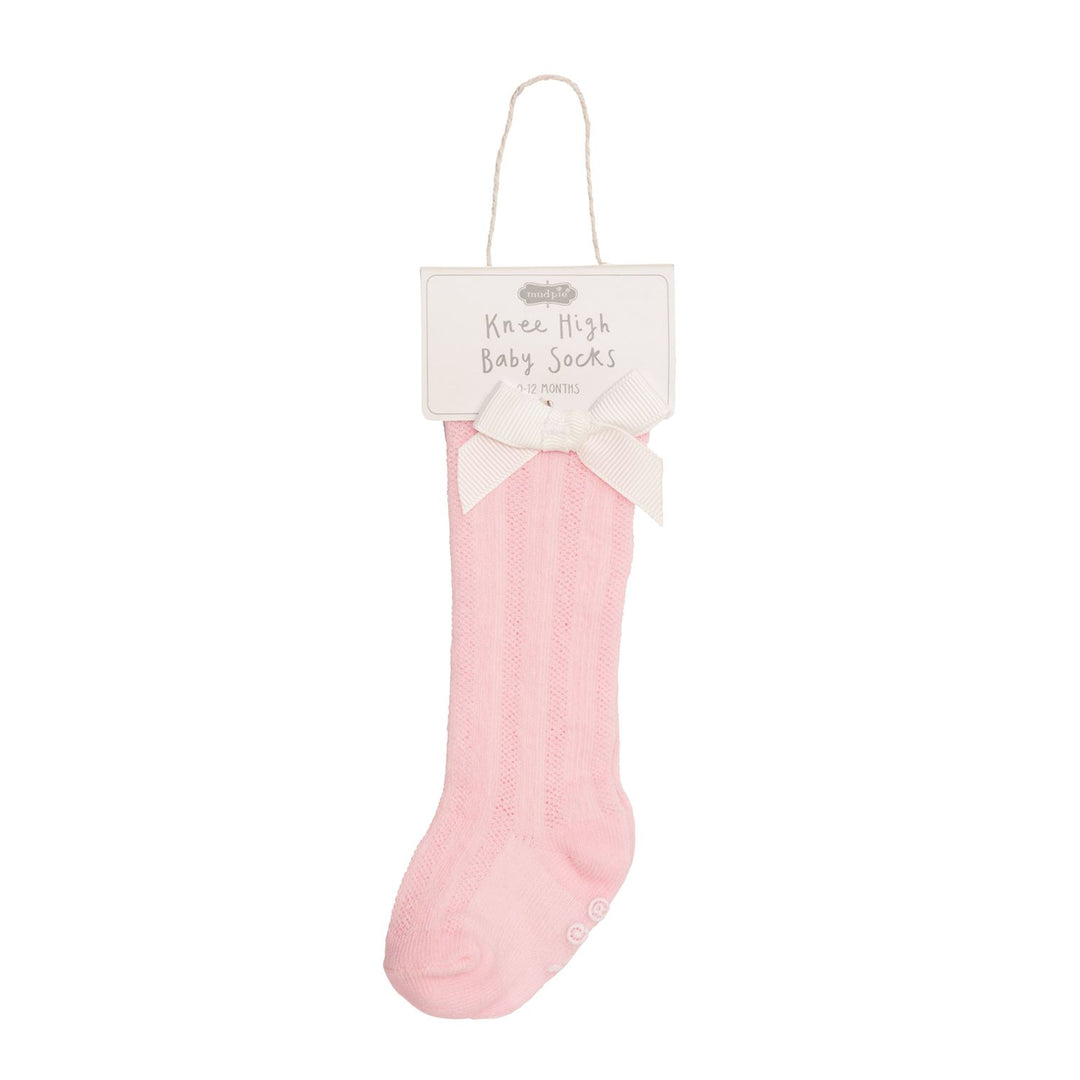 Pink knee-high cotton socks for babies featuring a delicate tacked bow on the side.