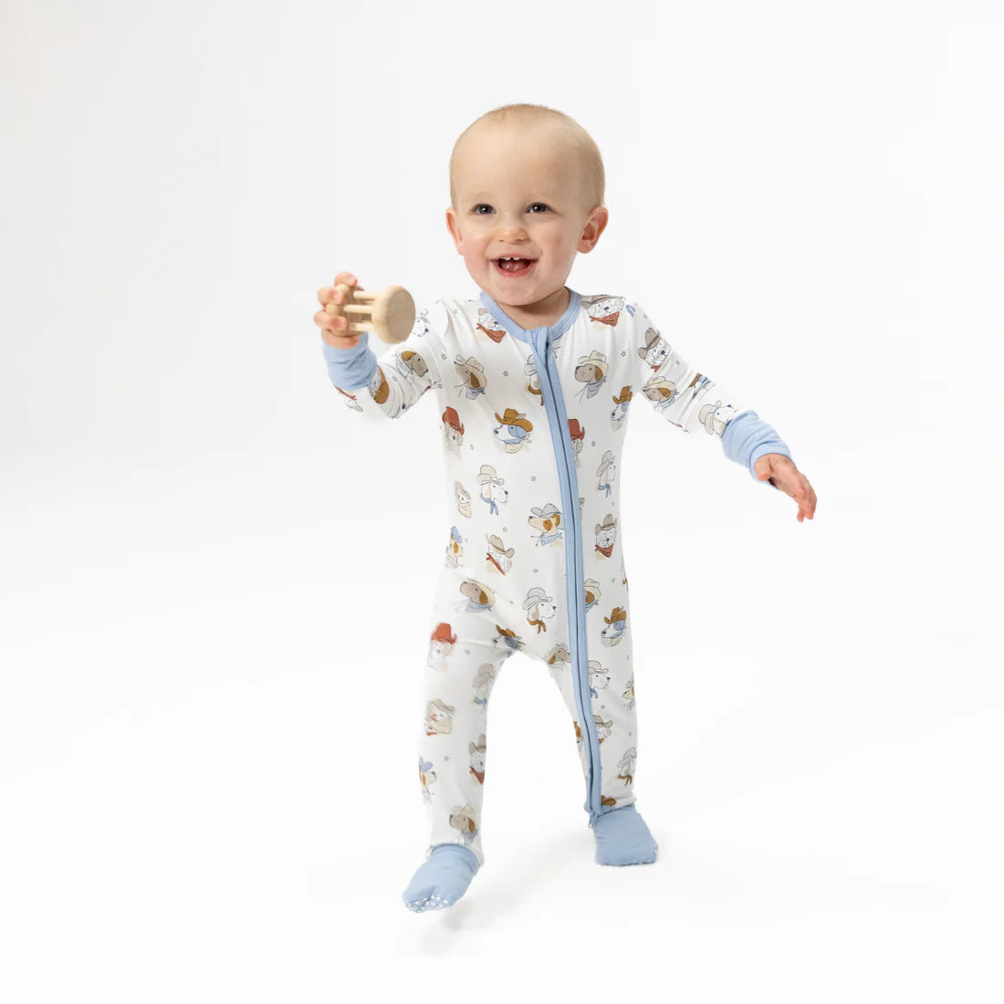 light blue bamboo baby romper with construction vehicle print featuring trucks and cranes