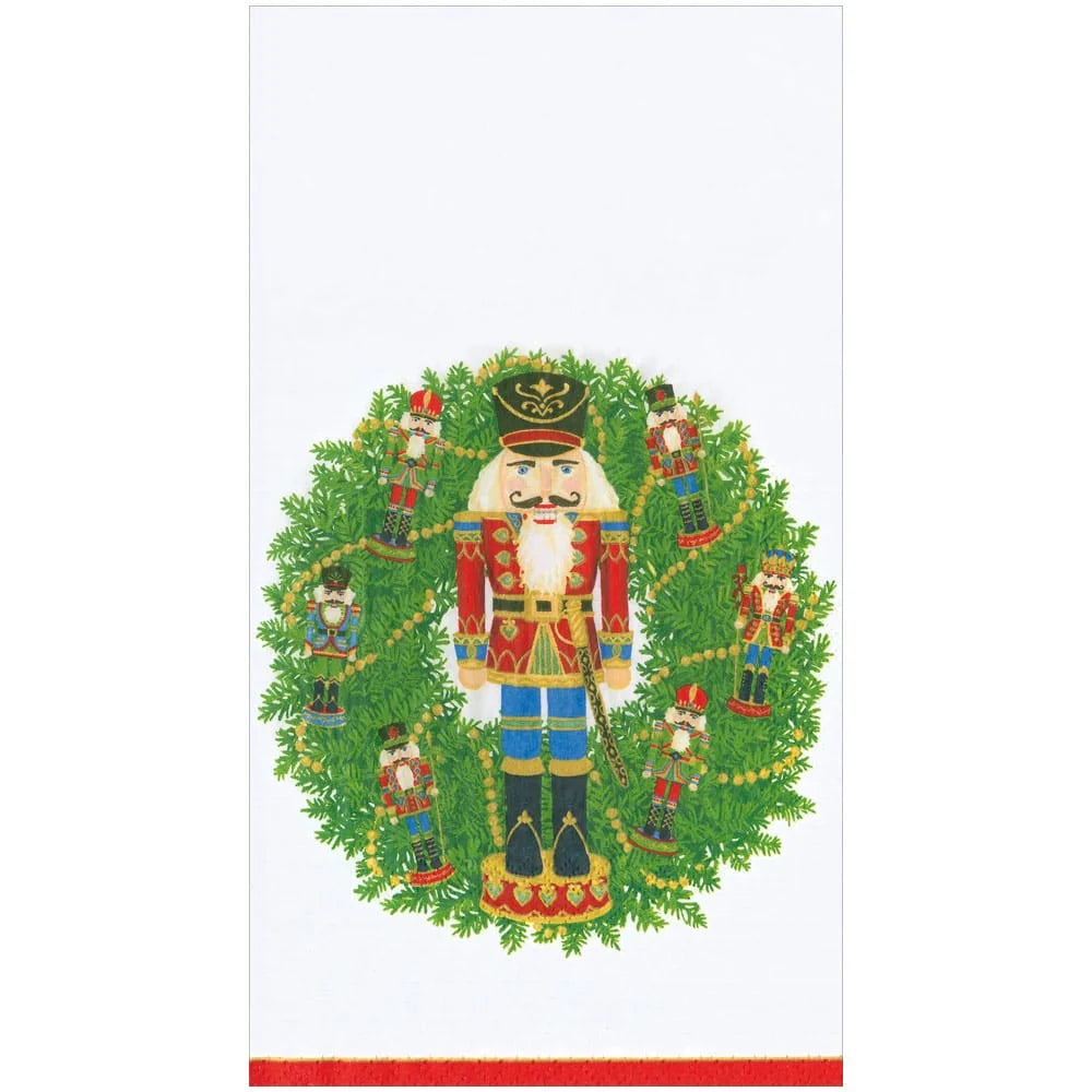 Caspari Nutcracker Wreath Guest Towels featuring a cheerful nutcracker, lush evergreen wreath, and festive red border.