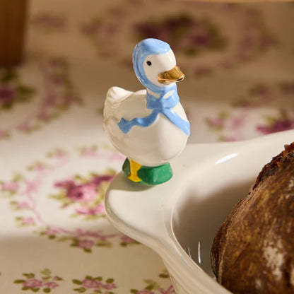Porch Pal goose mini displayed on a Nora Fleming white ceramic platter for a spring table setting.
