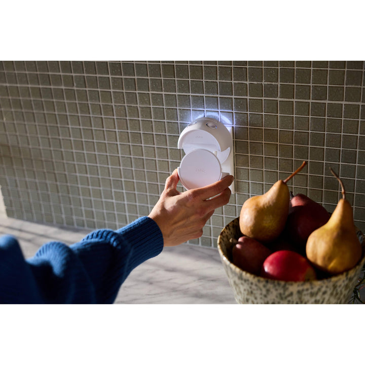 Using the manual buttons on the Pura Home diffuser on a tile kitchen backsplash