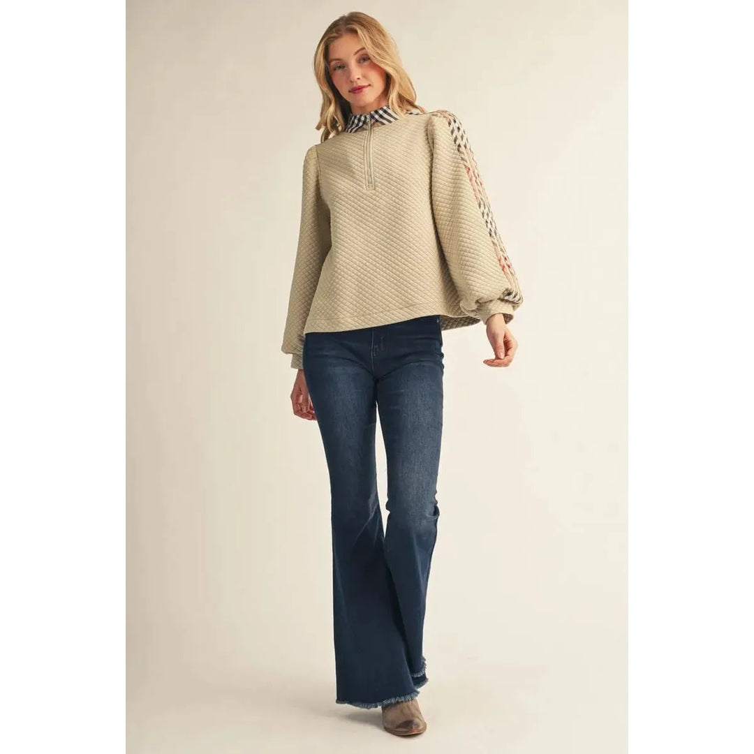 Model wearing the beige Jodifl Quilted Long Sleeve Top featuring puff sleeves and plaid contrast detail.