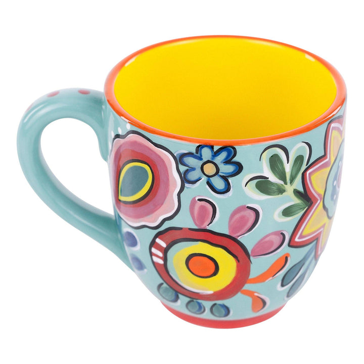 Glory Haus hand-painted 16oz coffee mug featuring a bright turquoise floral design with a yellow interior.