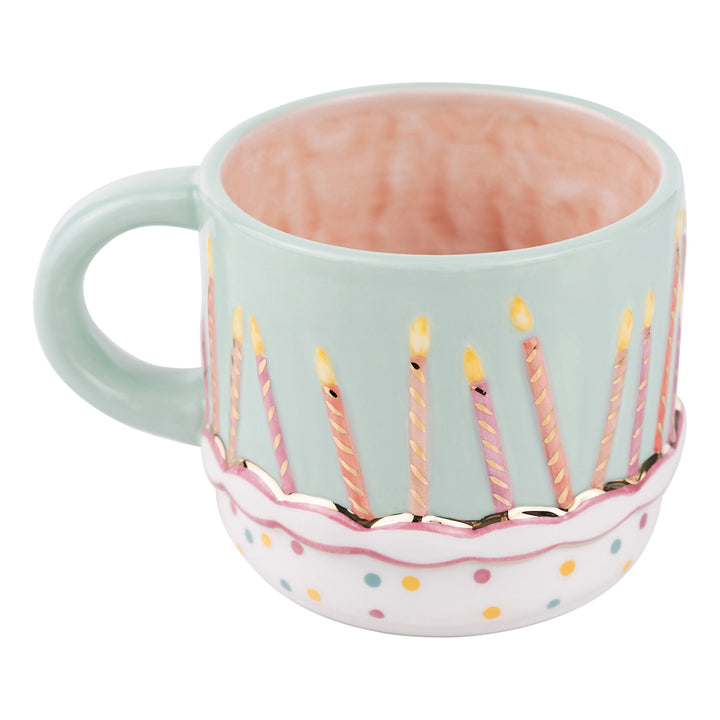 Glory Haus ceramic coffee mug featuring a festive hand-painted birthday cake and colorful candles with an aquamarine blue interior rim accent.