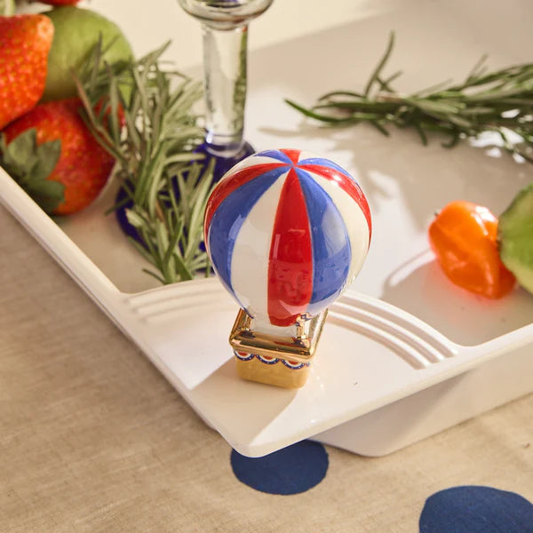 Nora Fleming hot air balloon mini inserted into a white ceramic platter for a festive patriotic table setting.