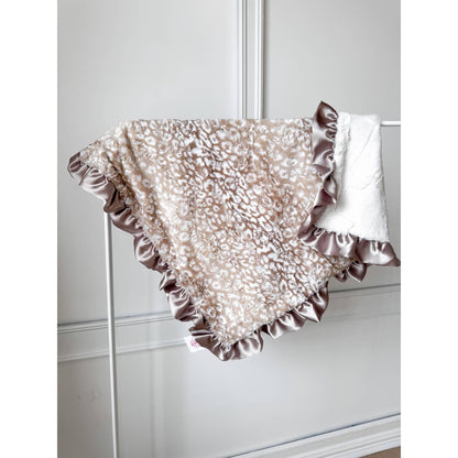 Rockin Royalty Lovely Leopard Lux Cuddle Blanket featuring a cream and tan ocelot faux fur pattern and tan ruffled satin edges.