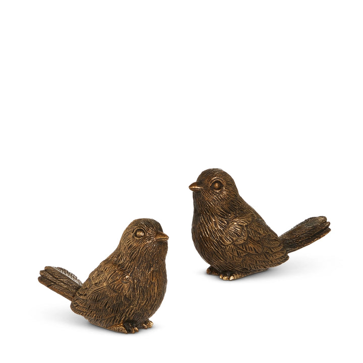 Two bronze bird figurines on a white background
