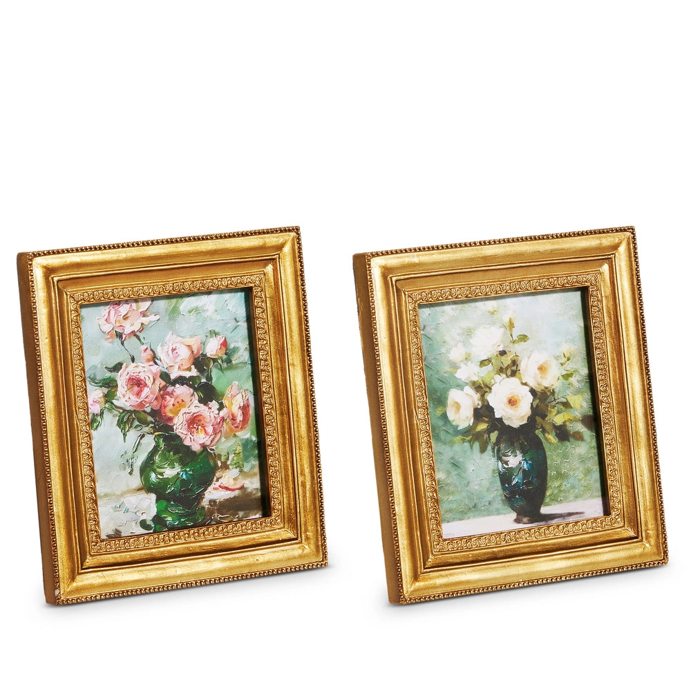 Two gold-framed pictures of floral arrangements on a white background