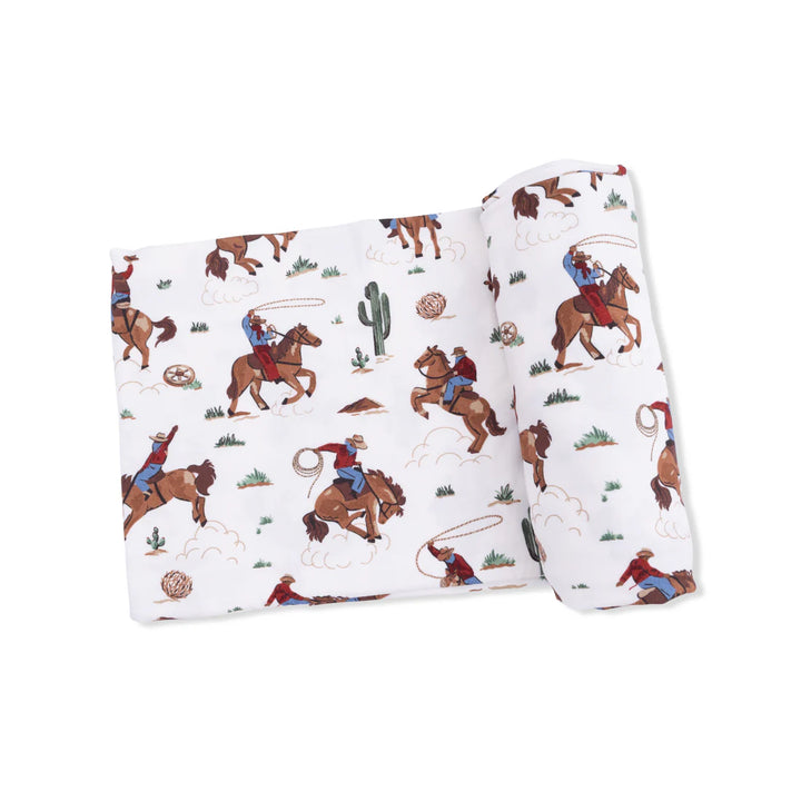 Infant bamboo swaddle blanket with Buckaroo Western print featuring cowboy boots and hats.