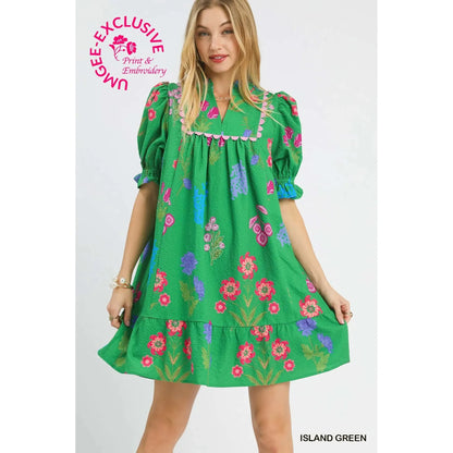 Woman wearing a green dress with floral embroidery on a white background