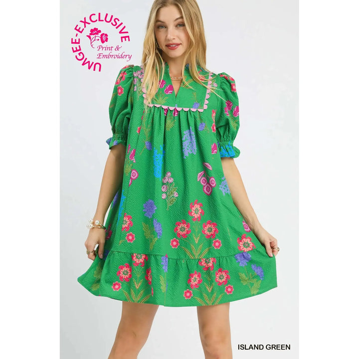 Woman wearing a green dress with floral embroidery on a white background