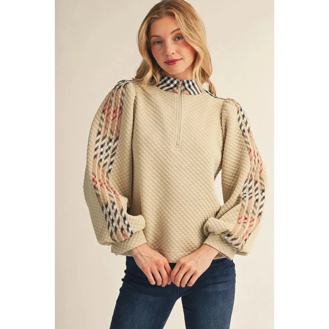 Model wearing the beige Jodifl Quilted Long Sleeve Top featuring puff sleeves and plaid contrast detail.
