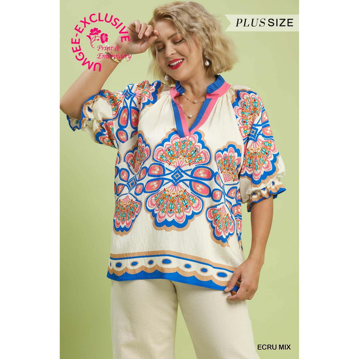 Model wearing the plus-size Umgee Mix Boho Print V-Neck Top in Ecru Mix featuring a contrast trim V-neck, flutter sleeves, and a flowy fit.
