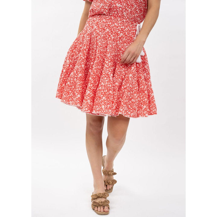 Model wearing the Ivy Jane Rosie red floral tiered skirt with tassel ties, Spring 2026 boutique fashion.