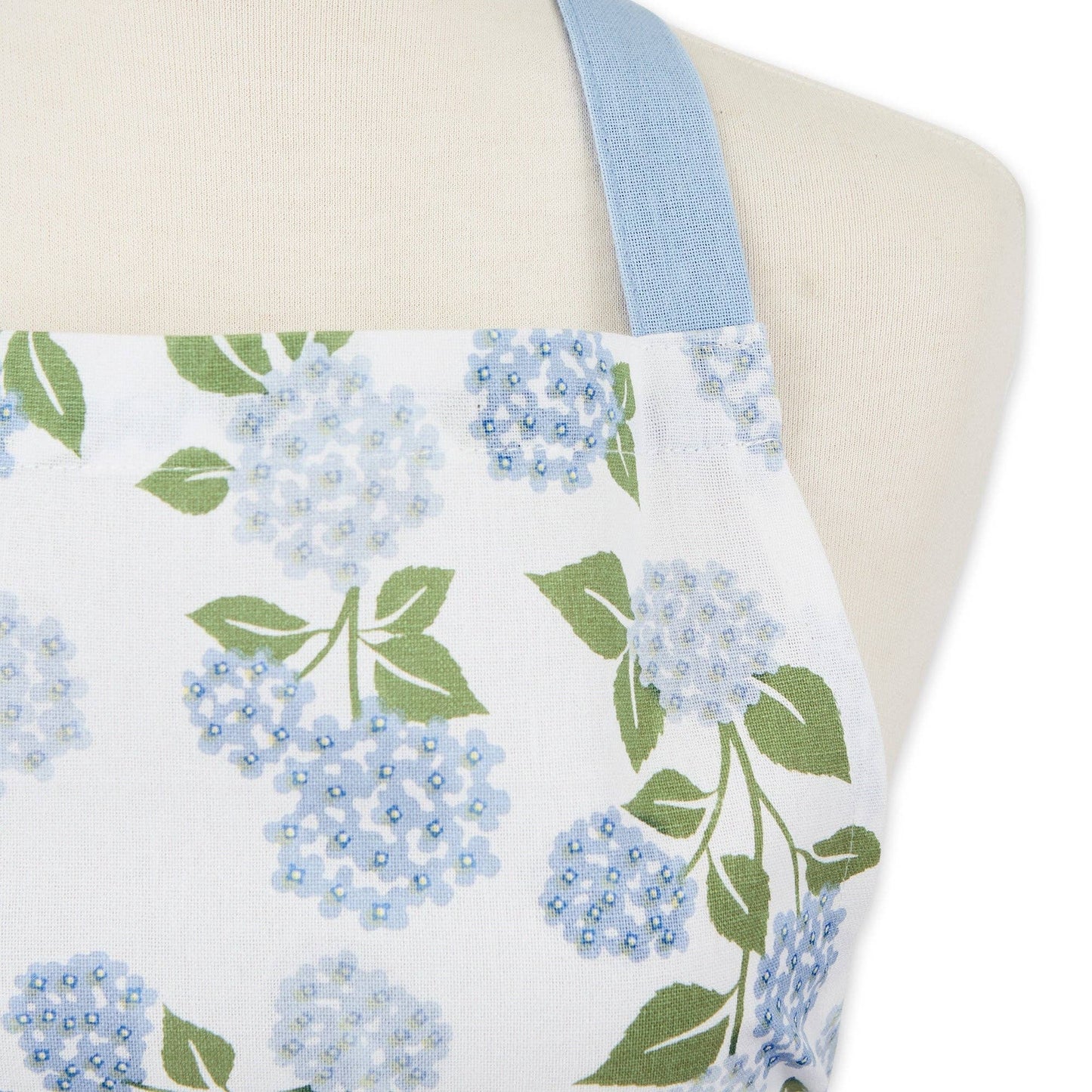 Close-up of the botanical hydrangea pattern on a cotton apron, highlighting the reinforced stitching on the deep front pocket.