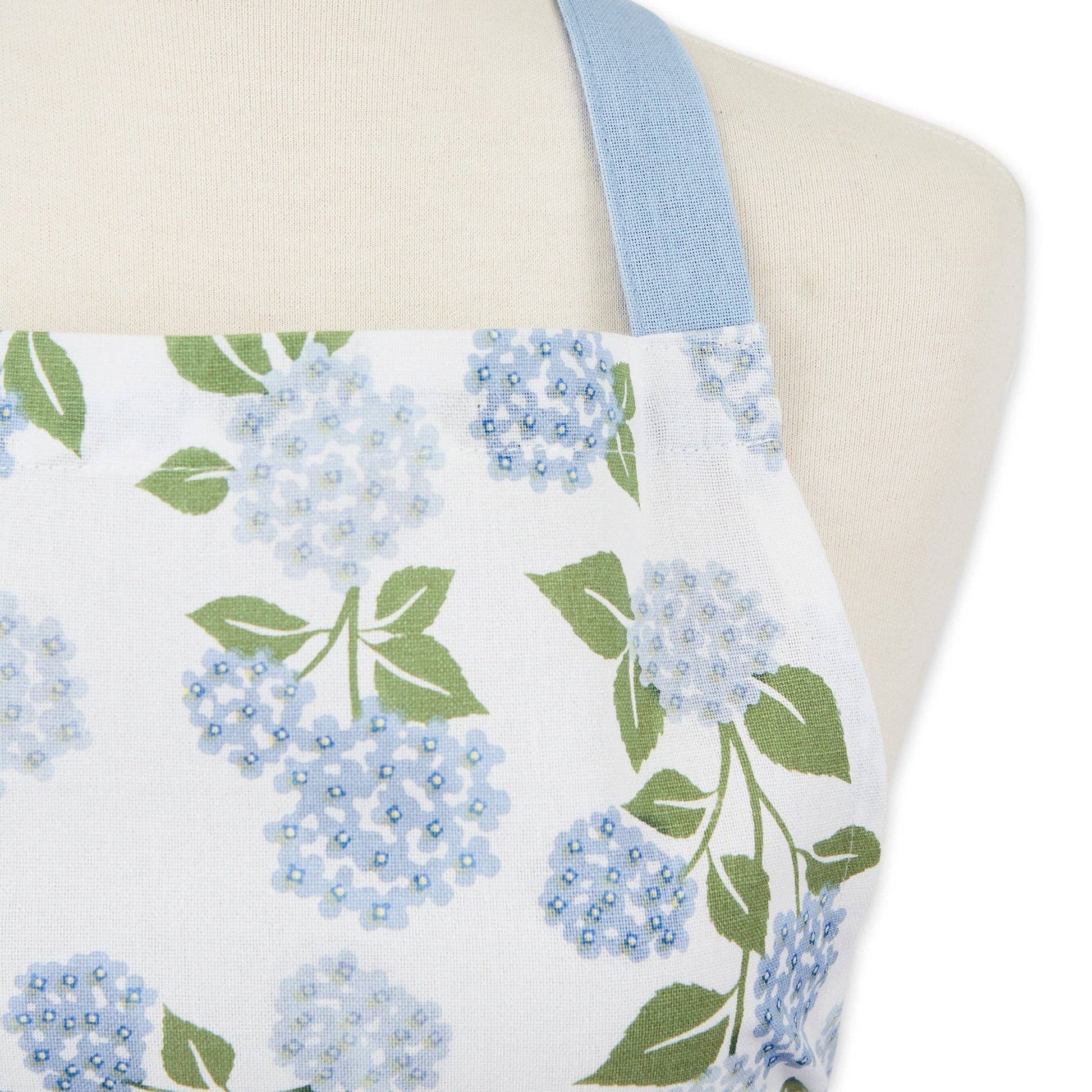 Close-up of the botanical hydrangea pattern on a cotton apron, highlighting the reinforced stitching on the deep front pocket.