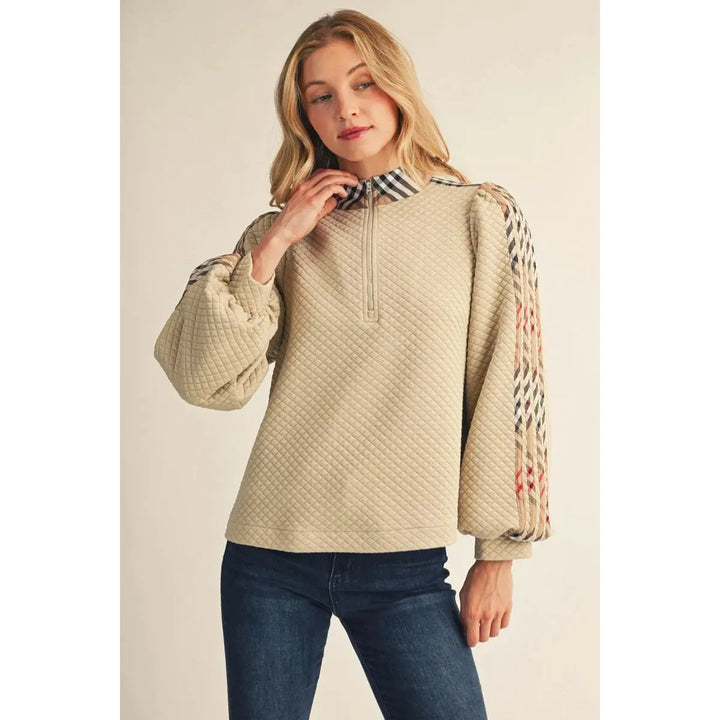 Model wearing the beige Jodifl Quilted Long Sleeve Top featuring puff sleeves and plaid contrast detail.