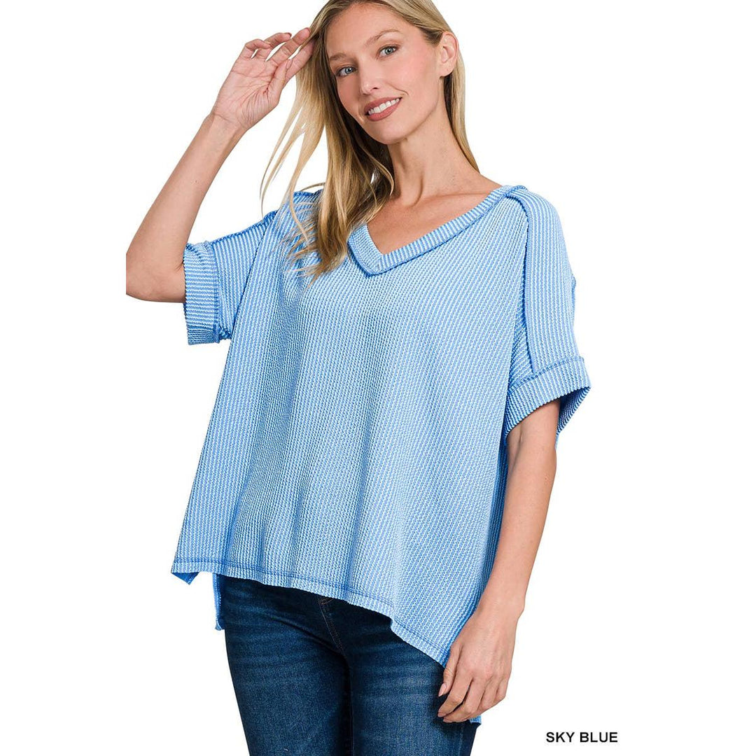 Model wearing a sky blue 42POPS short sleeve top featuring a corded rib texture, V-neckline, and a relaxed hi-low hem.