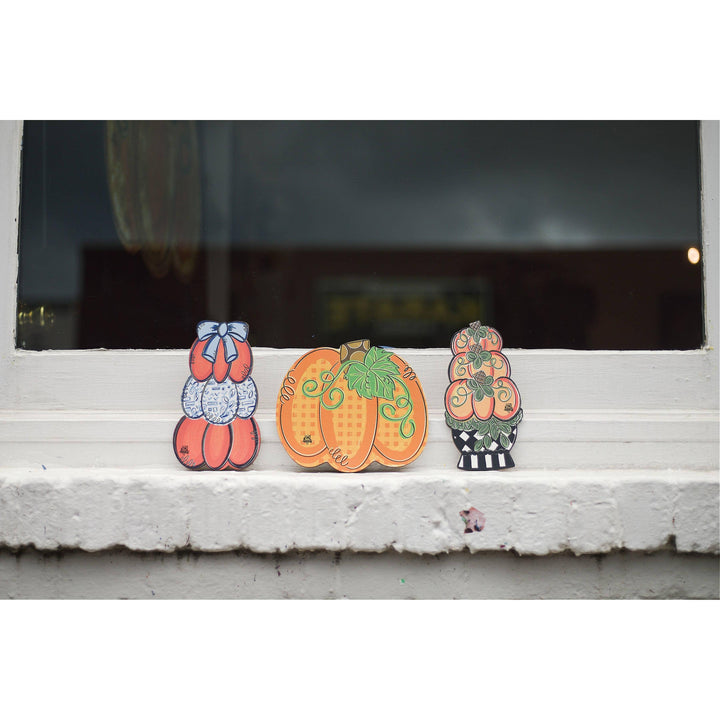 DK Designs Georgia gingham pumpkin mini displayed on a windowsill with stacked pumpkin minis