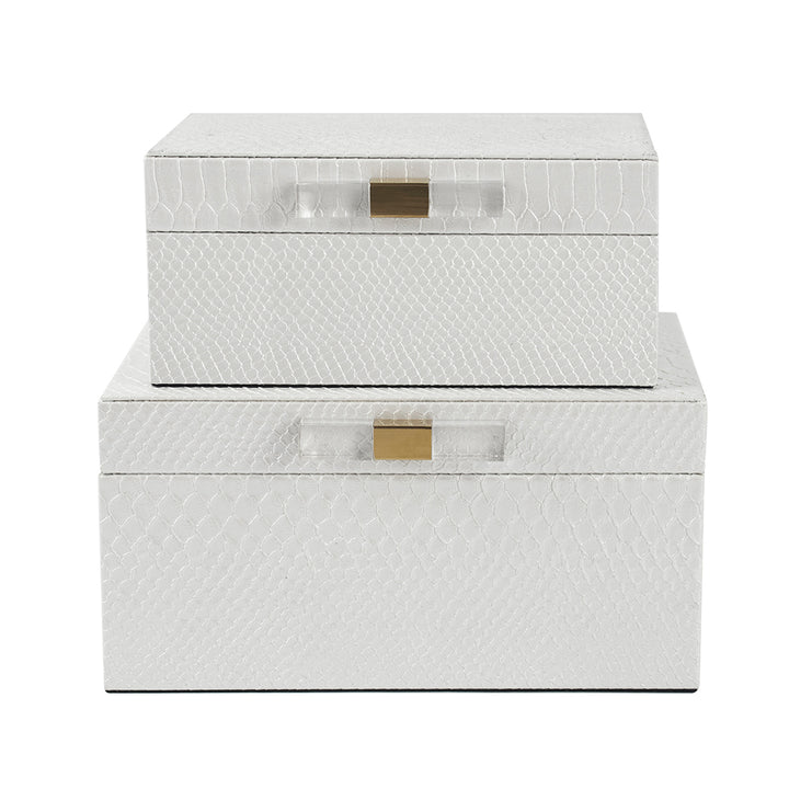 Set of two white textured storage boxes with gold latches on a white background