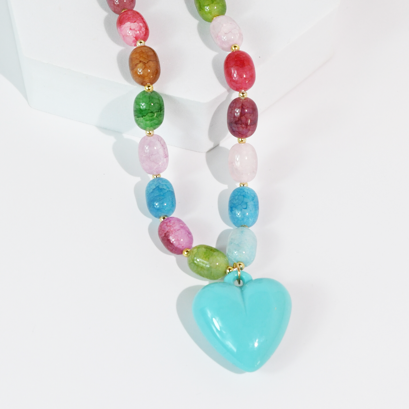 Colorful beaded necklace with a heart-shaped pendant on a white background
