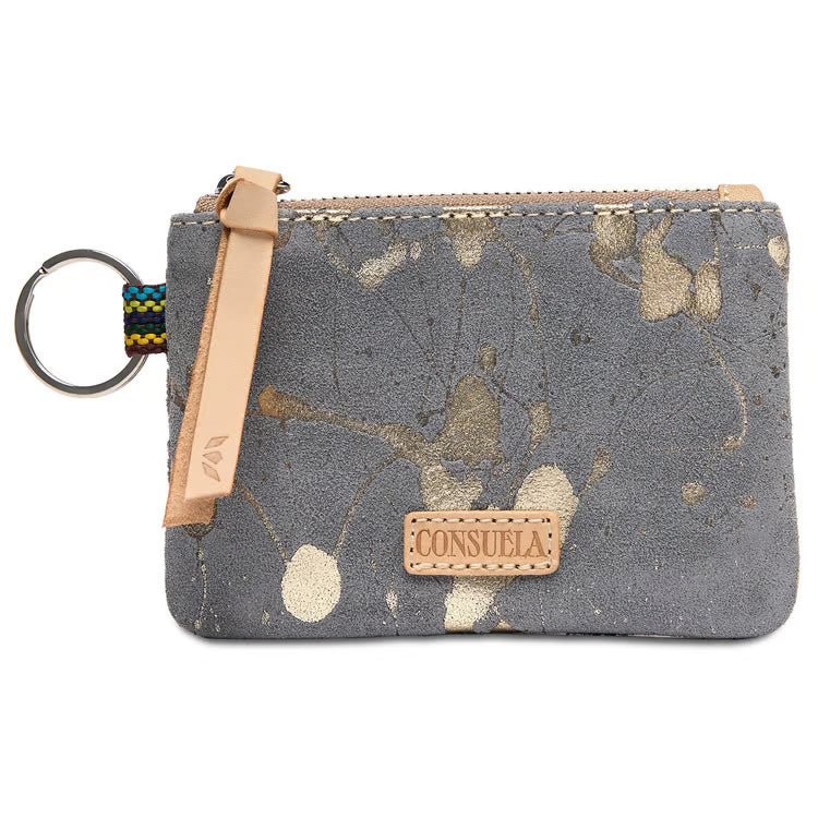 Consuela Jagger Pouch in distressed denim-blue fabric with gold paint-splatter detailing, front view with a natural leather zipper pull, a beaded keyring, and a Consuela nameplate.