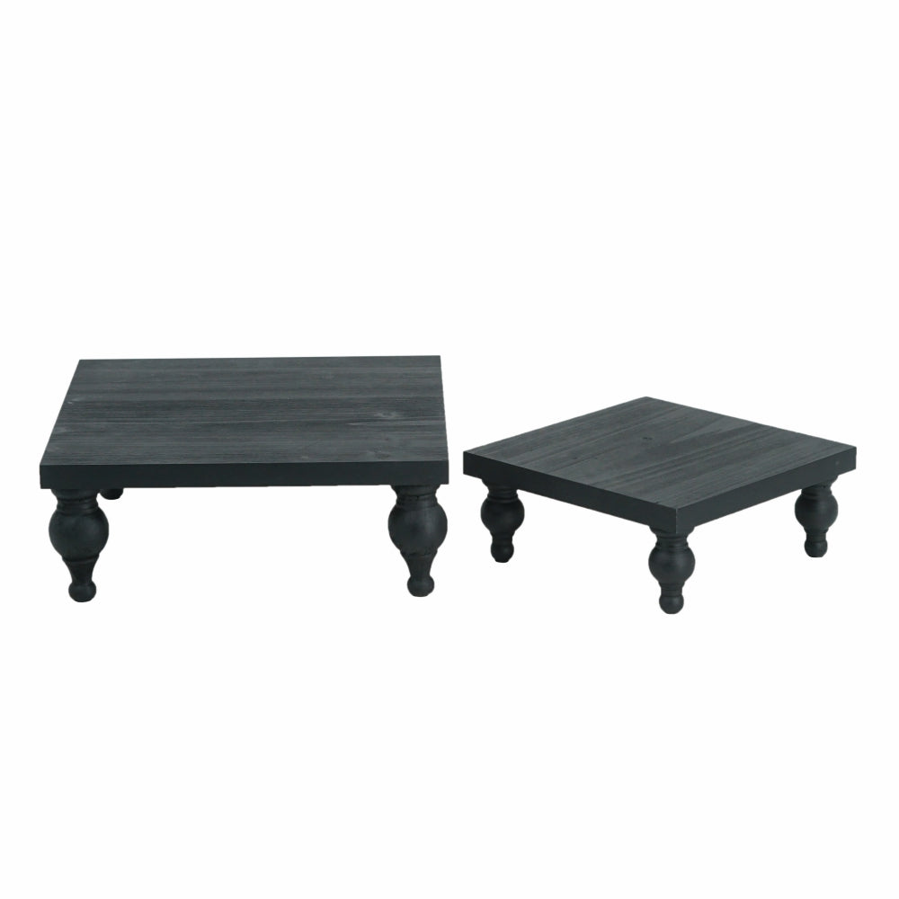Two black square tables with curved legs on a white background