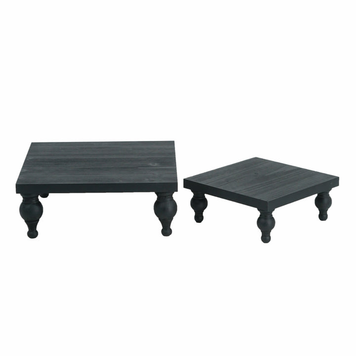 Two black square tables with curved legs on a white background