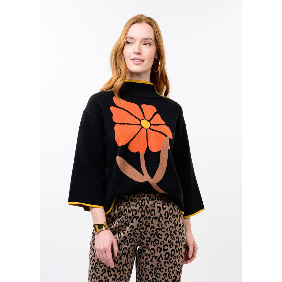 Model wearing the black Ivy Jane bold flower sweater featuring a large rust-colored floral design.