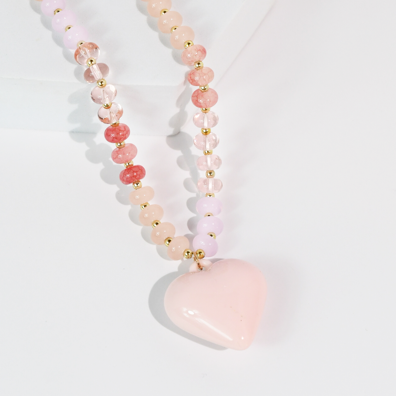 Necklace with pink heart pendant on a light gray background