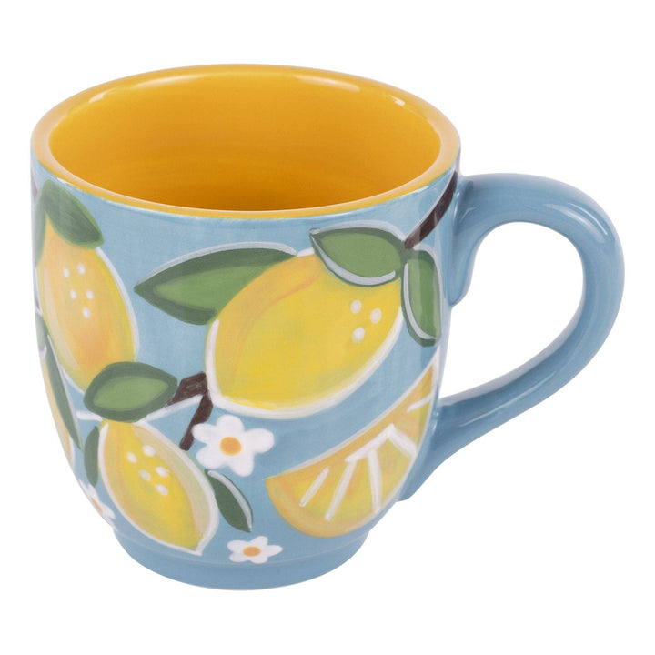 Glory Haus Lots of Lemons ceramic coffee mug showing a vibrant, hand-painted yellow lemon pattern on a crisp white and blue base.