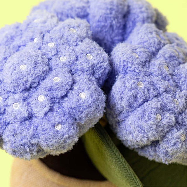 Close-up of the friendly face and textured petals of the Amuseables Hydrangea stuffed toy