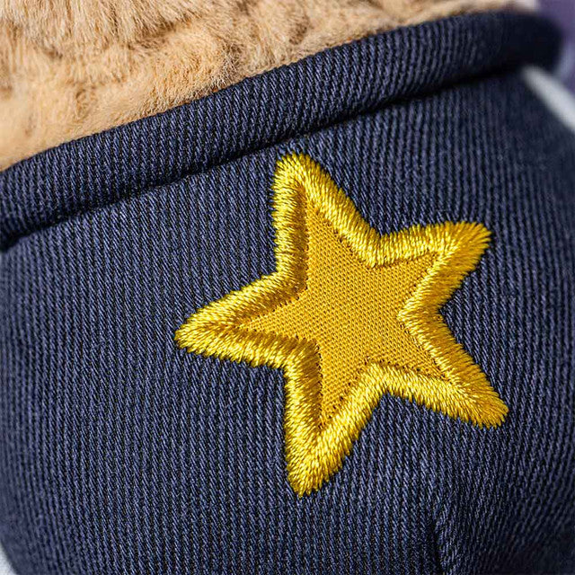 close-up of the ruffled fabric texture and embroidered smiley face on the Amuseables Peanut.
