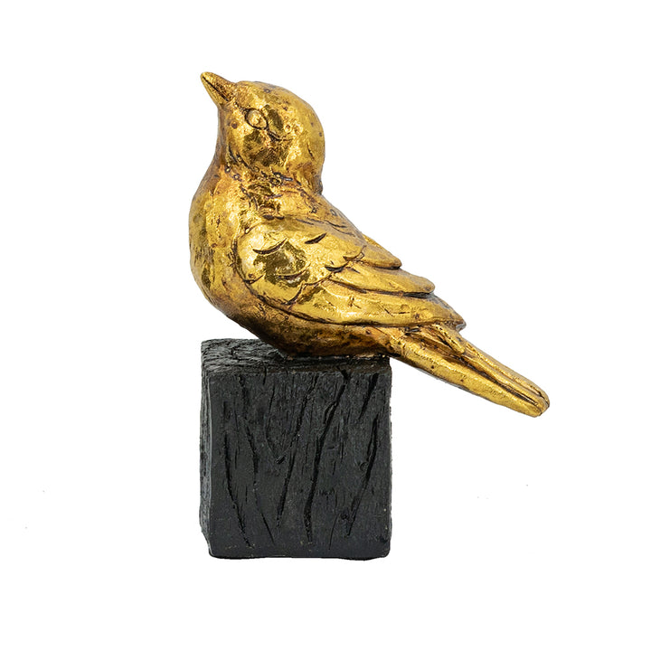 Gold bird figurine on a black base against a white background