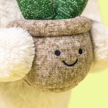 Close-up of the Jellycat Cream Bunny’s face and the textured plush leaves of her plant companion.