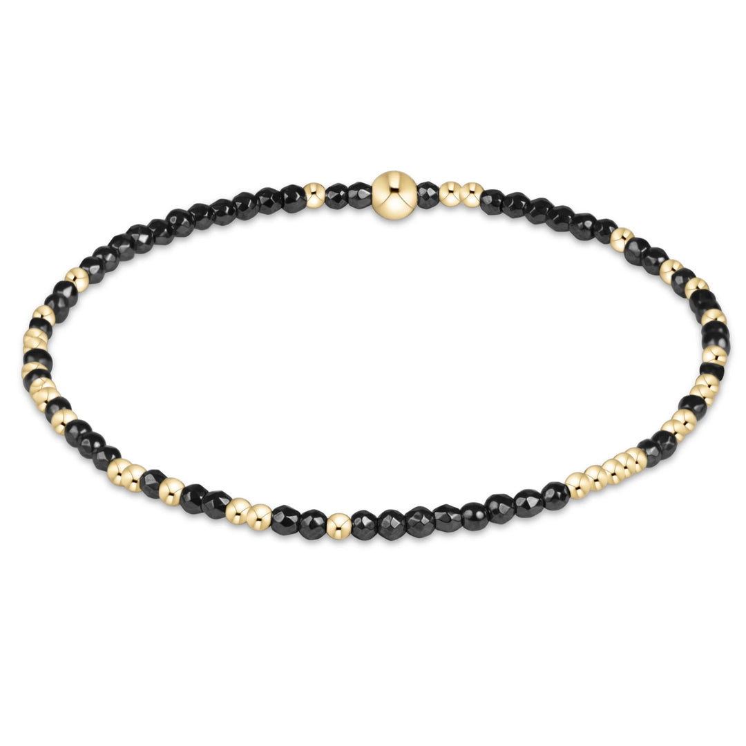 enewton Hope Unwritten Faceted Hematite 2mm beaded stretch bracelet featuring dark grey faceted beads and a colorful mixed bead accent.