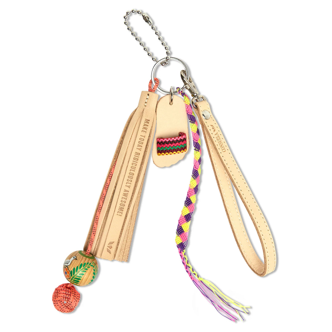 Consuela Lumi bag charm featuring a natural Diego leather tassel, a hand-woven friendship bracelet, and a hand-painted floral charm.