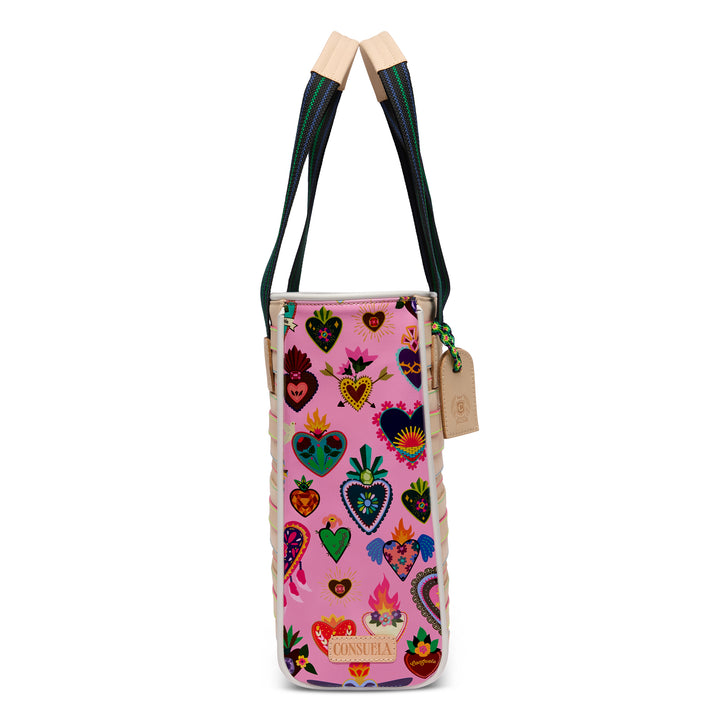Side view of the Consuela Caroline Classic Tote showing the pink side panel covered in colorful folk-art sacred hearts and a Consuela nameplate.