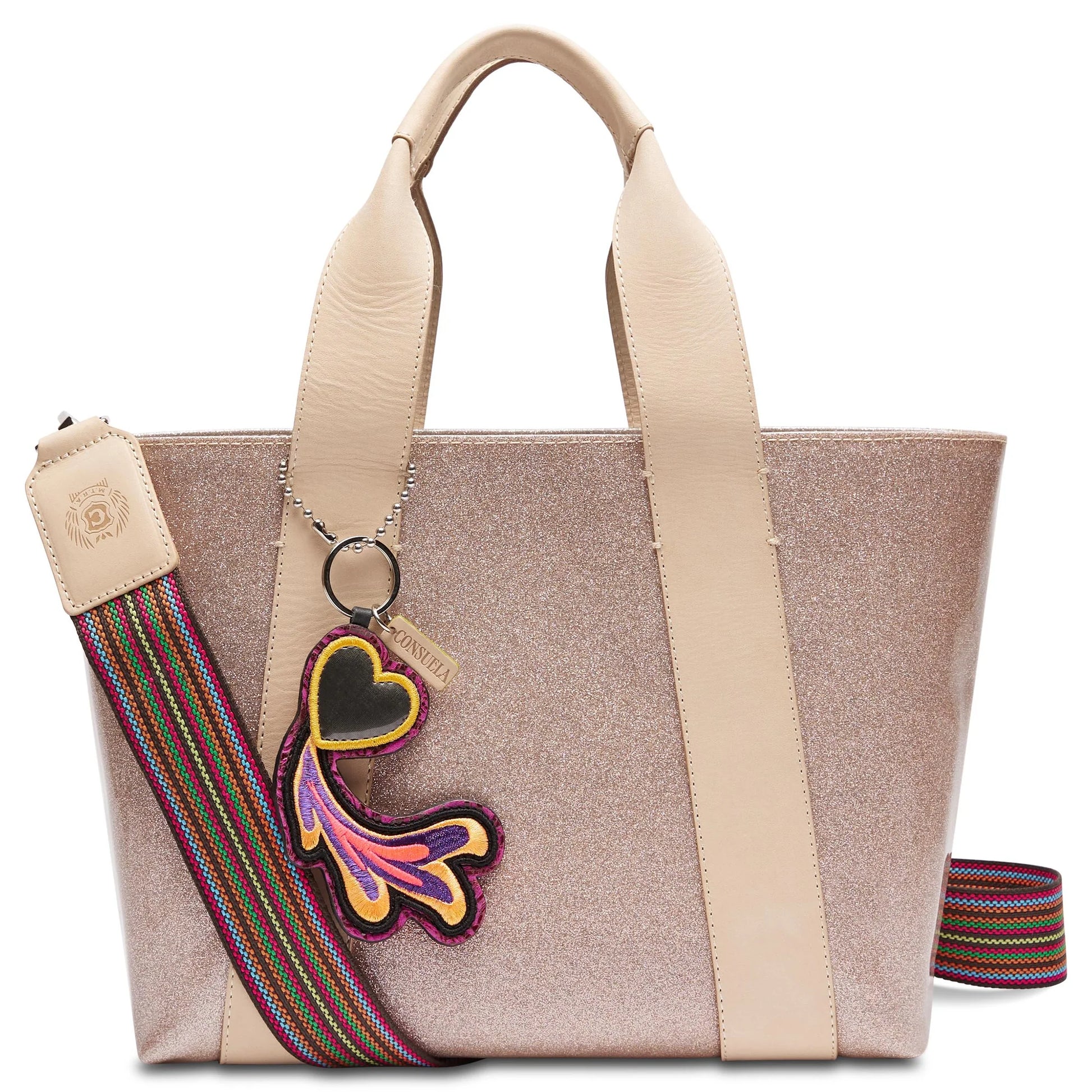 Consuela Emery Carryall featuring a champagne glitter exterior, natural leather handles, and a colorful woven crossbody strap.
