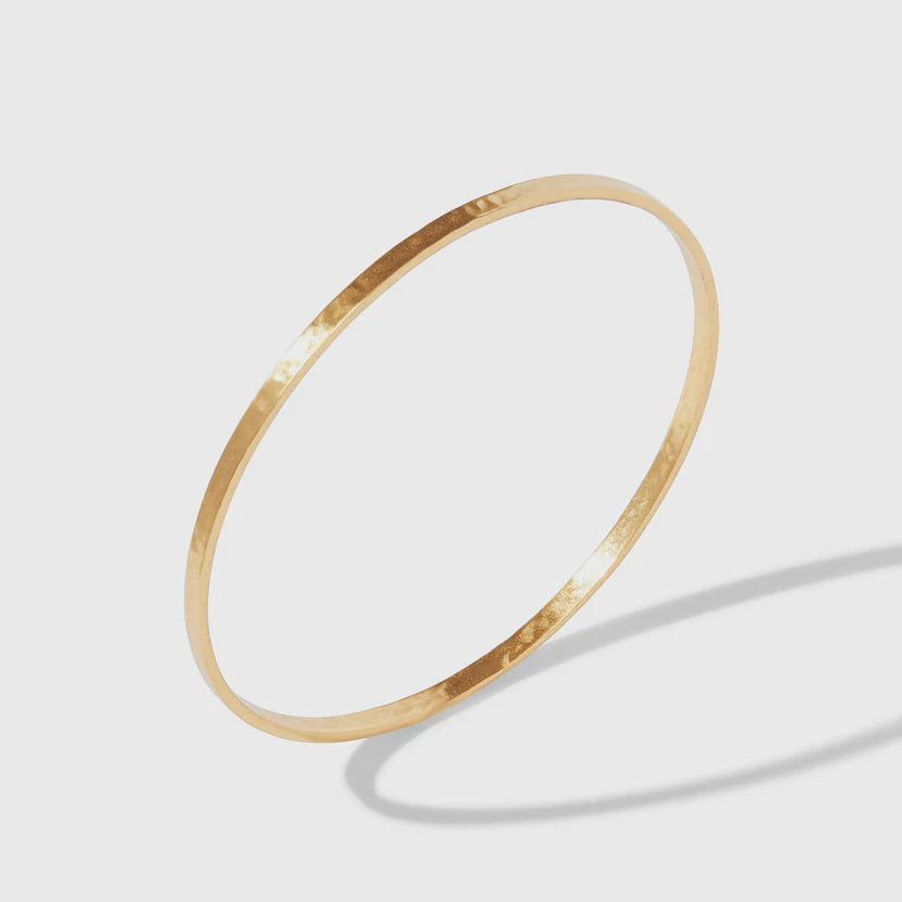 Close-up of the Julie Vos hallmark and the lightly hammered gold texture of the Crescent Bangle.