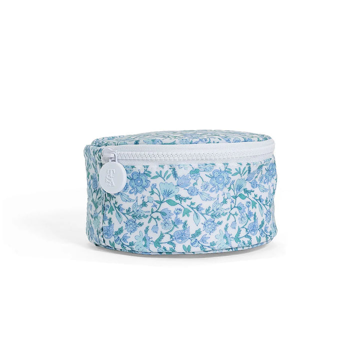 Round blue and white floral jewelry travel case with a white chunky zipper and interior elastic pockets.