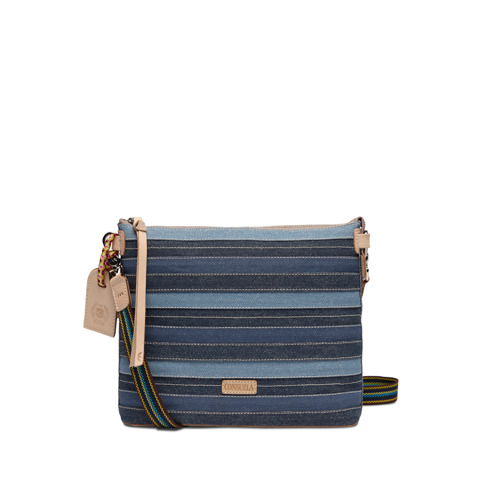 Consuela Royal Downtown Crossbody in denim-inspired blue stripes, front view with a colorful woven strap draped to the side.